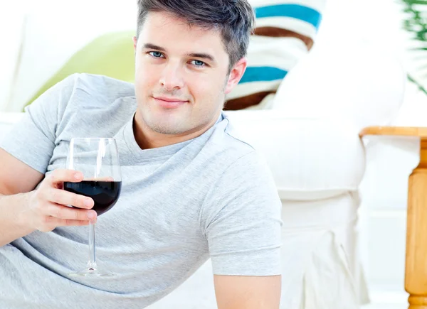 Encantador hombre caucásico sosteniendo una copa de vino en el salón — Foto de Stock
