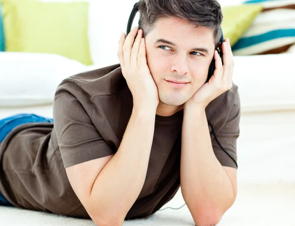 Çekici bir adam yerde yatıyor müzik dinlemek — Stok fotoğraf