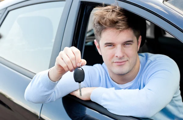 Γοητευτικό νέος άνθρωπος που κρατά ένα αυτοκίνητο που κάθεται στο αυτοκίνητό του — Φωτογραφία Αρχείου
