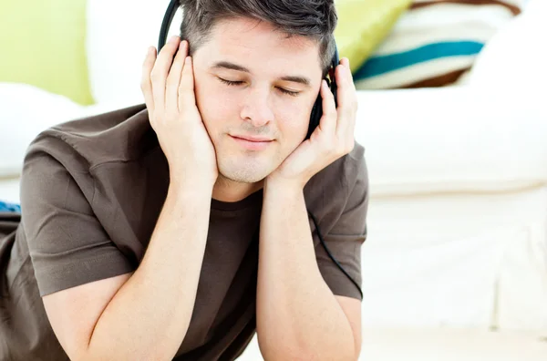 Расслабленный мужчина слушает музыку, лежащую на полу — стоковое фото