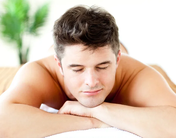 Retrato de um homem atraente deitado em uma mesa de massagem — Fotografia de Stock