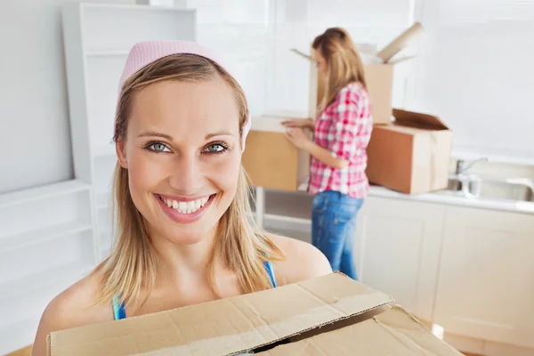 Dos mujeres positivas llevando cajas en casa —  Fotos de Stock
