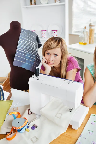 Depressed woman sewing clothes in the kitchen — Stock Photo, Image