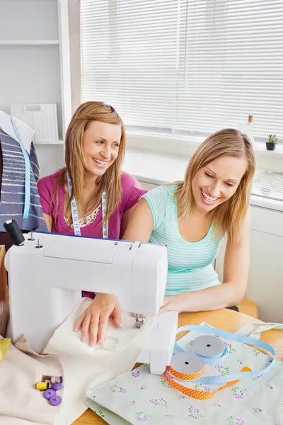 Geanimeerde vrouwelijke vrienden samen naaien van kleding — Stockfoto