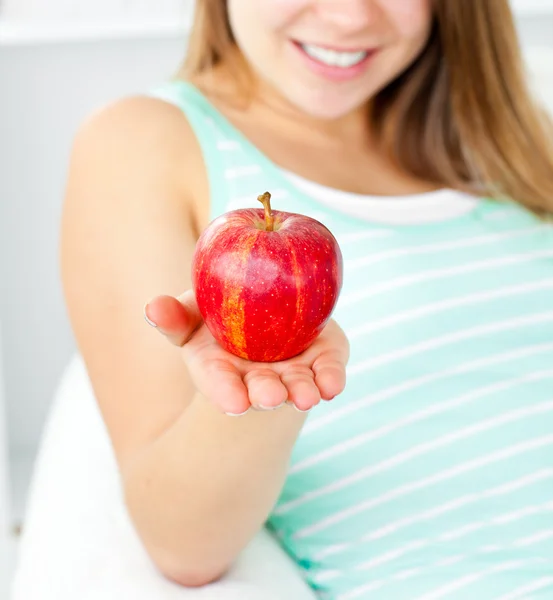 Słodkie młoda kobieta trzyma jabłko w dłoni — Zdjęcie stockowe