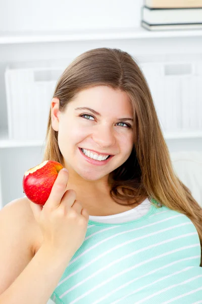 Elma elinde tutan gülümseyen genç kadın — Stok fotoğraf