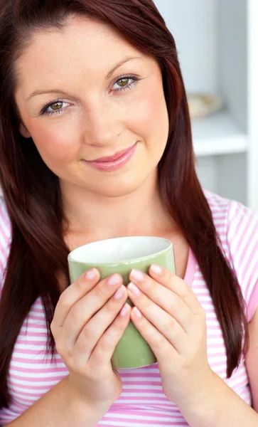 Mulher feliz segurando uma xícara de café na cozinha — Fotografia de Stock