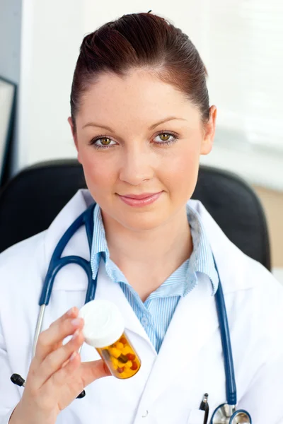 Close-up van een geconcentreerde vrouwelijke arts pillen houden — Stockfoto