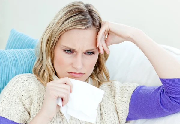 Diseased woman lying on a sofa with tissues — Stock Photo, Image