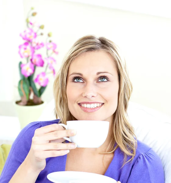 Mutlu genç kadın kahve kanepe üzerinde tutan — Stok fotoğraf