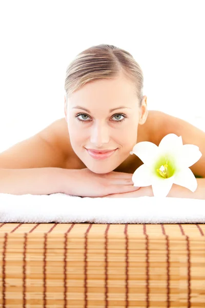 Close-up of a radiant woman lying on a massage table with a flow — Stock Photo, Image