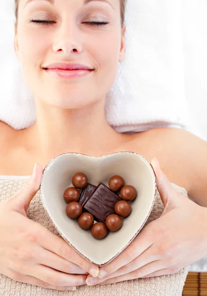 Mujer brillante sosteniendo un tazón en forma de corazón con chocola —  Fotos de Stock
