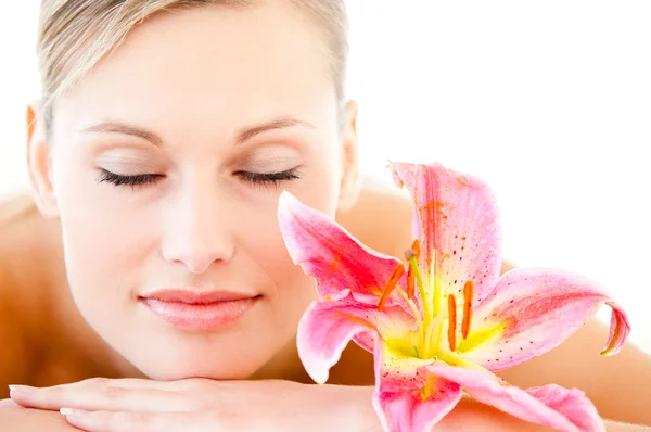 Close-up of a pretty woman lying on a massage table with a flowe — Stock Photo, Image