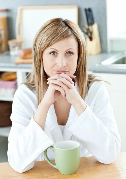 Mulher loira caucasiana séria desfrutando de seu café na cozinha — Fotografia de Stock