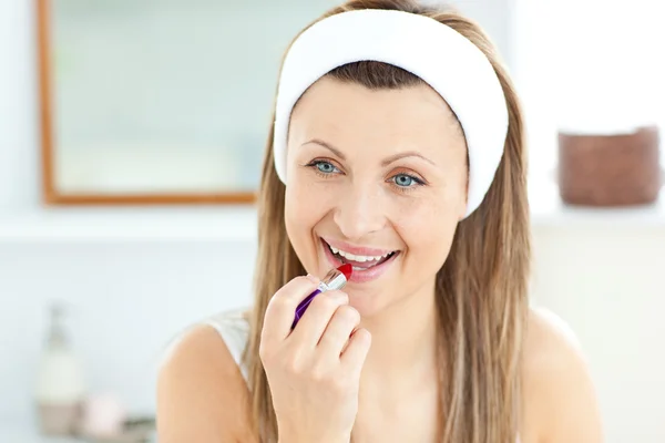 Mujer joven y bonita usando un lápiz labial rojo en el baño — Foto de Stock