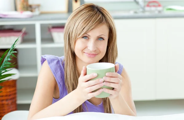 Mulher brilhante segurando uma xícara de café na cozinha — Fotografia de Stock