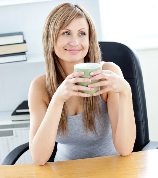 彼女のオフィスでコーヒーのカップを保持しているリラックスした実業家 — ストック写真