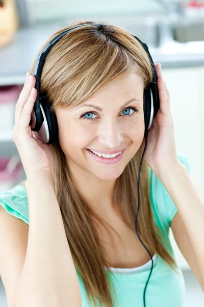 Heldere Kaukasische vrouw luisteren naar muziek met koptelefoon in de — Stockfoto