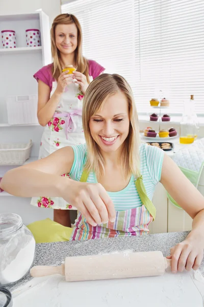 Smiling female friends baking pastry in the kitchen — Stock Photo, Image