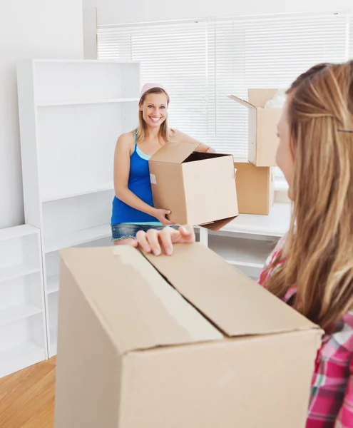 Two smiling women carrying boxes at home — Stock Photo, Image