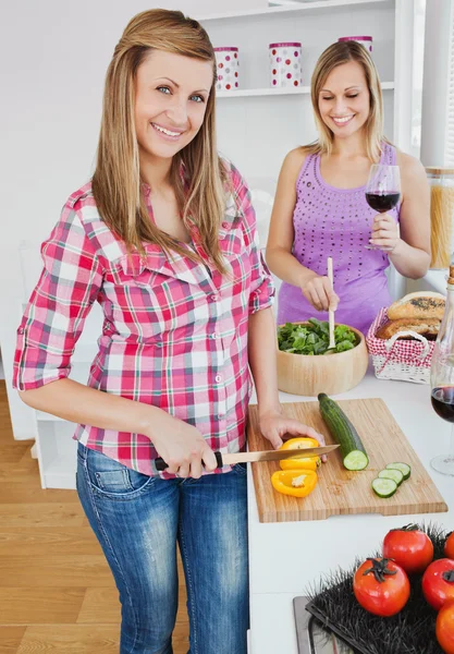 Twee lachende vrouwen samen koken thuis — Stockfoto