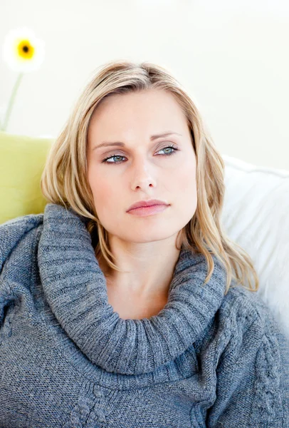 Müde Frau liegt mit grauem Pullover auf dem Sofa — Stockfoto