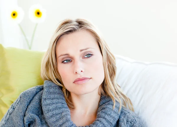 Utmattad kvinna liggande på soffan med en grå tröja — Stockfoto