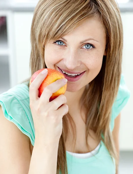 Magával ragadó kaukázusi nő eszik almát, a konyhában — Stock Fotó