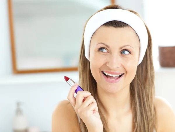 Glad ung kvinna med ett rött läppstift i badrummet — Stockfoto
