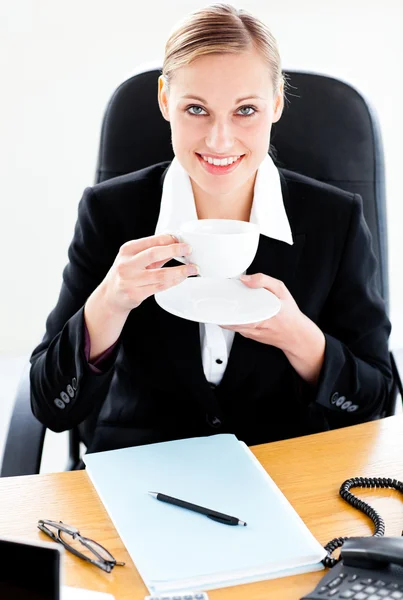 Donna d'affari caucasica radiosa che tiene un caffè seduto davanti a lei — Foto Stock