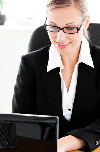 Busy young businesswoman using her laptop sitting at her desk — Stock Photo, Image