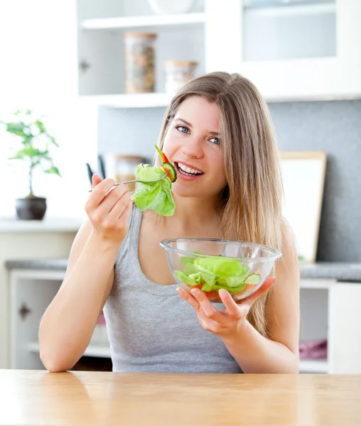 Donna brillante che mangia insalata in cucina — Foto Stock
