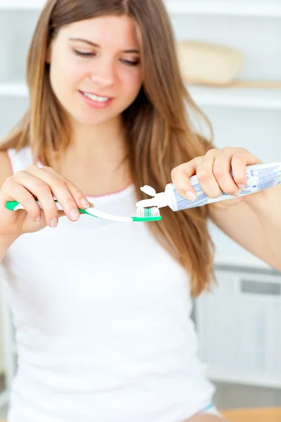 Vacker kvinna med en tandborste och tandkräm i badrum — Stockfoto