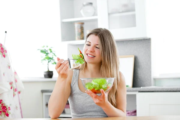 Czarujący dama jedzenie sałatka w kuchni — Zdjęcie stockowe