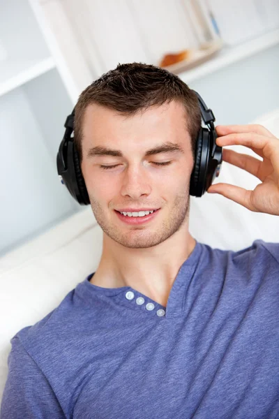 Entspannter junger Mann hört Musik mit Kopfhörern in der Limousine — Stockfoto