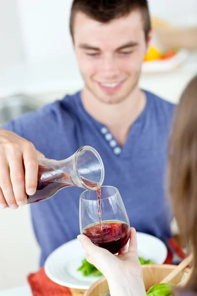 Netter Mann speist mit seiner Freundin zu Hause und serviert ihr Wein — Stockfoto