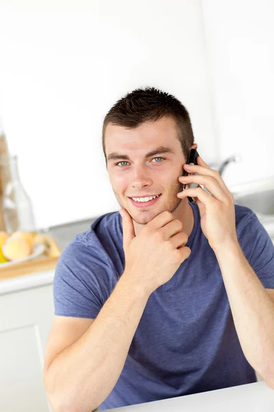 Csinos, fiatal férfi talkng a telefon és a fényképezőgép mosolyogva — Stock Fotó