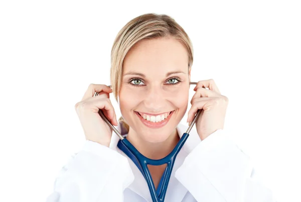 Уверенная женщина-врач держит стетоскоп, улыбаясь в камеру. — стоковое фото