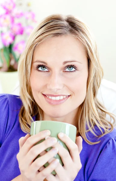 Donna attraente godendo il suo caffè seduto su un divano nel li — Foto Stock