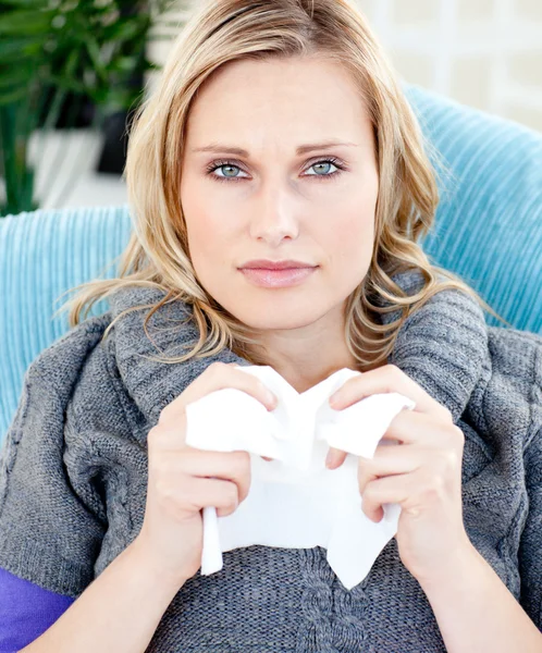 Mujer enferma usando un pañuelo sentado en un sofá — Foto de Stock