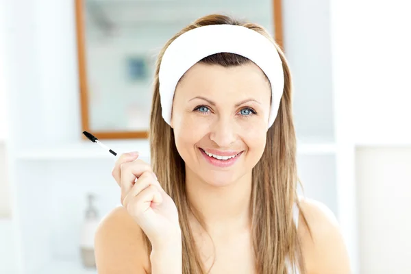 辐射的年轻女子在浴室使用睫毛膏 — 图库照片