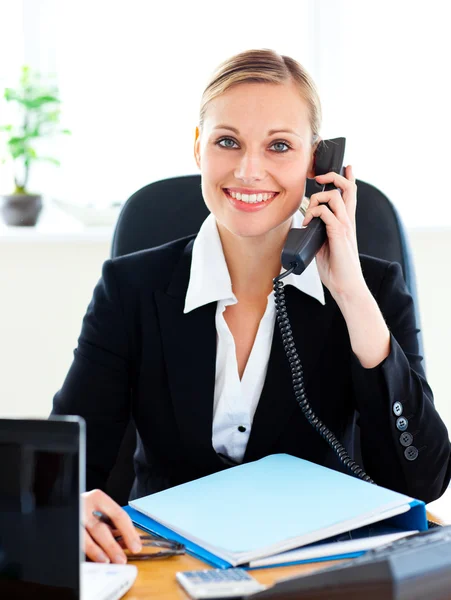 Stralende zakenvrouw praten over telefoon in haar kantoor — Stockfoto