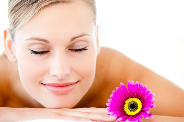 Close-up of a bright woman lying on a massage table with a flowe — Stock Photo, Image