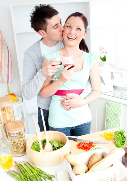 Amante casal preparando uma salada na cozinha e bebendo vinho — Fotografia de Stock