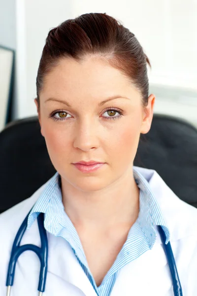 Serious female doctor smiling at the camera sitting — Stock Photo, Image