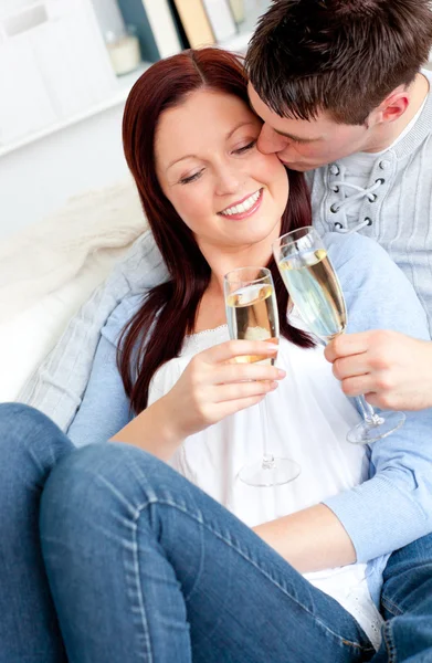 Atraktivní pár pití šampaňského ležel na pohovce — Stock fotografie