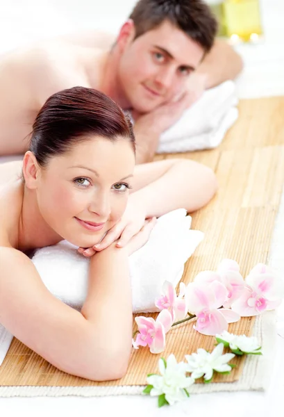 Casal jovem caucasiano deitado em uma mesa de massagem — Fotografia de Stock