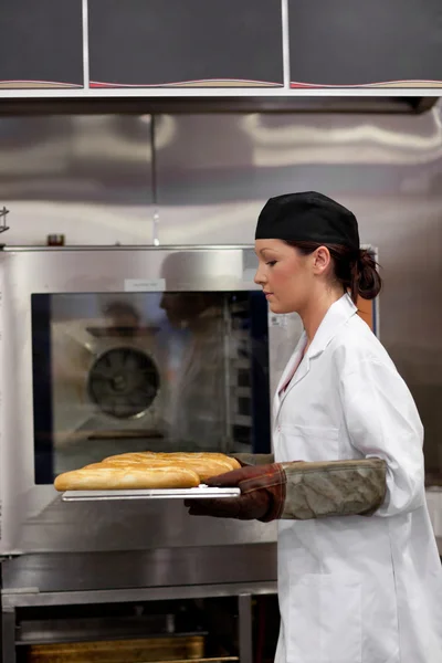 Charming young baker with baguettes — Stock Photo, Image
