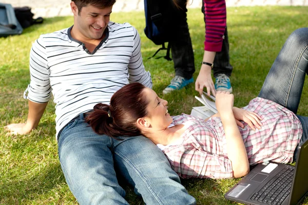 草の上に横たわる明るい学生のカップル — ストック写真