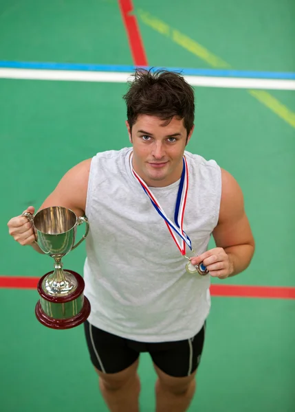 Joyeux jeune homme tenant un trophée et une médaille — Photo